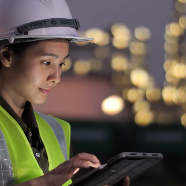 Woman in a hardhat working on tablet