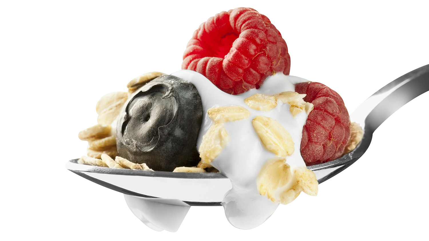 Some fruit, granola and yogurt on a spoon