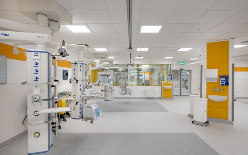 A hospital room with a large white wall and yellow walls, providing a bright and clean environment for patients
