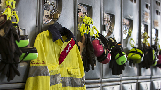 A row of energy equipment workers lockers with safety equipment on the doors