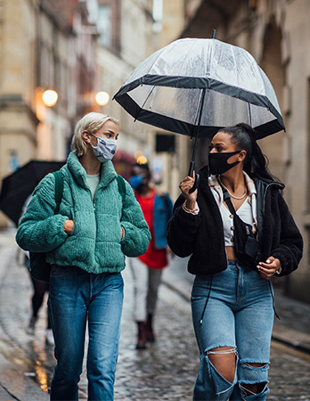 two women talking with masks