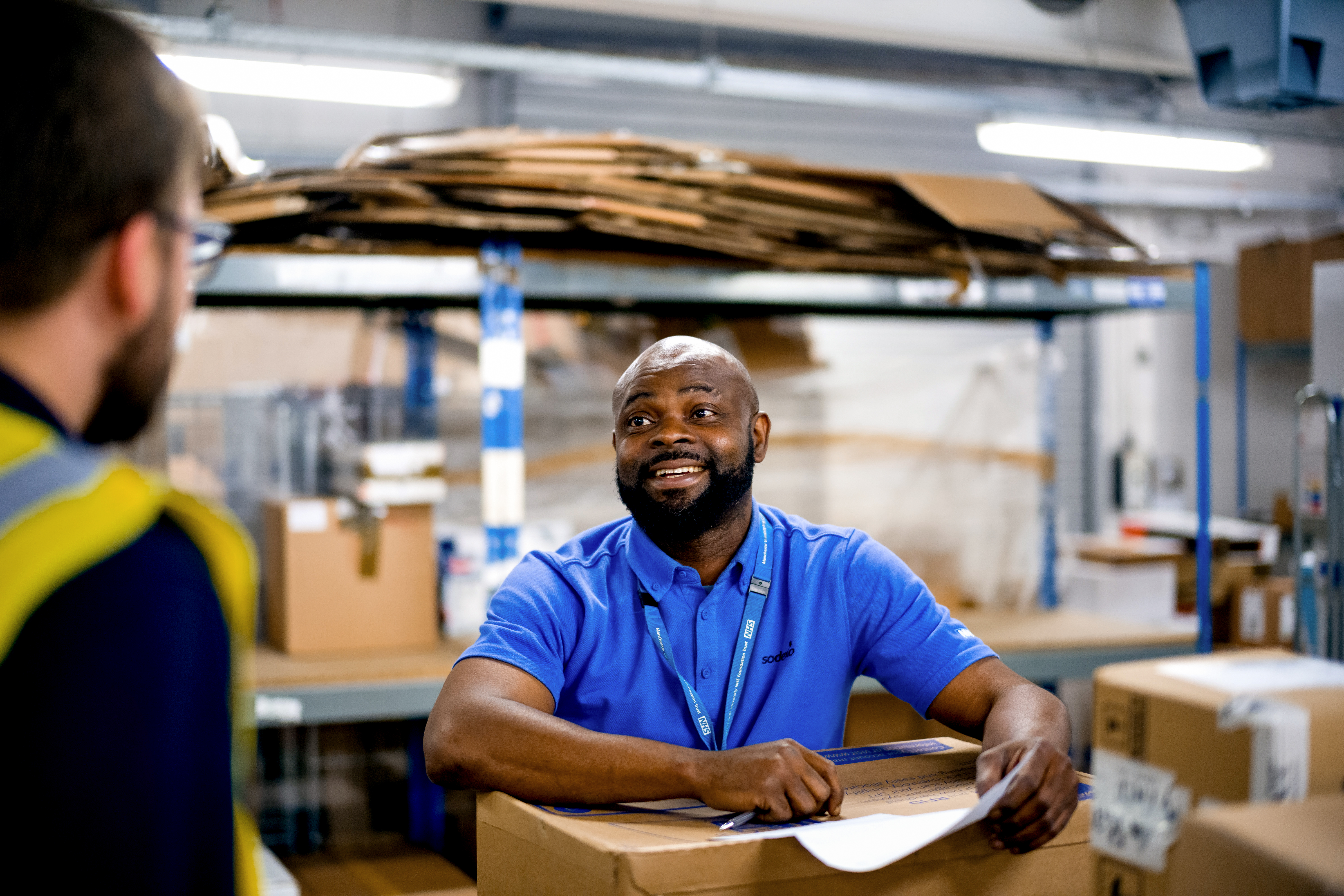 man talking to colleague in warehouse 